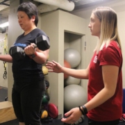 Women lifting weights with her physical therapist