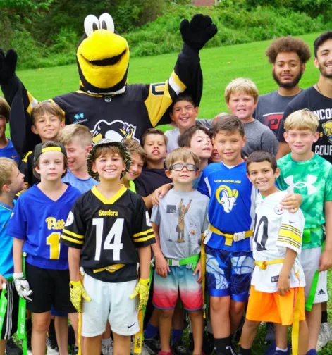 Group of kids taking a picture with the Pittsburgh penguin